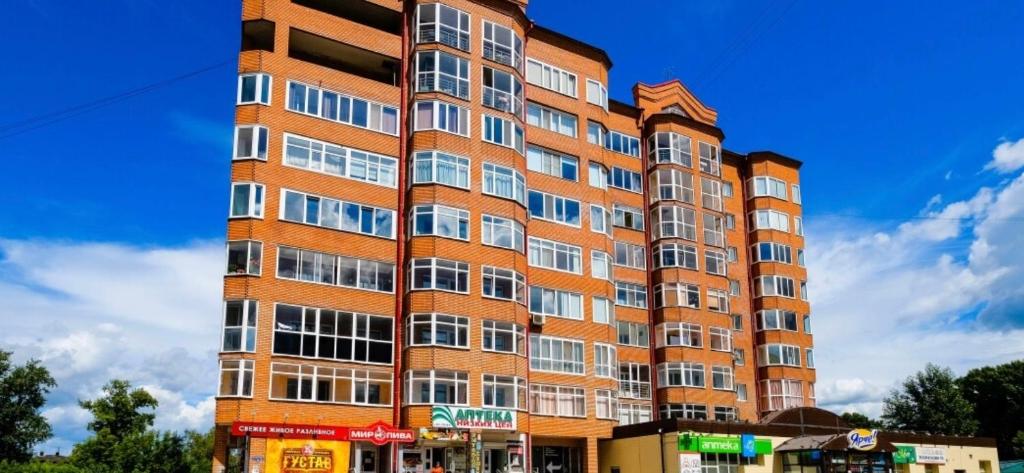トムスクにあるКварт отель Надежда Базарный 12の多くの窓がある赤レンガ造りの高い建物