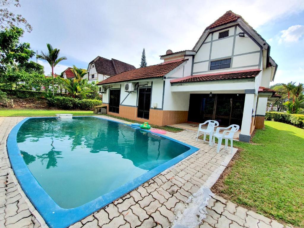 a swimming pool in front of a house at A famosa Resort Villa with private pool by BeeStay 10 pax in Kampong Alor Gajah