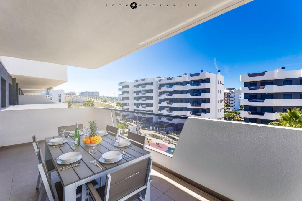 d'une table à manger sur un balcon avec vue sur les bâtiments. dans l'établissement Dunas Apartment, à Arenales del Sol