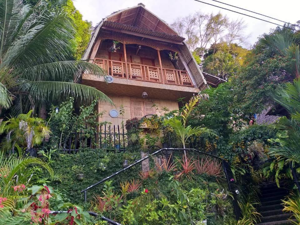 a house with a staircase leading up to it at Camiguin Blue Lagoon Cottages in Mahinog