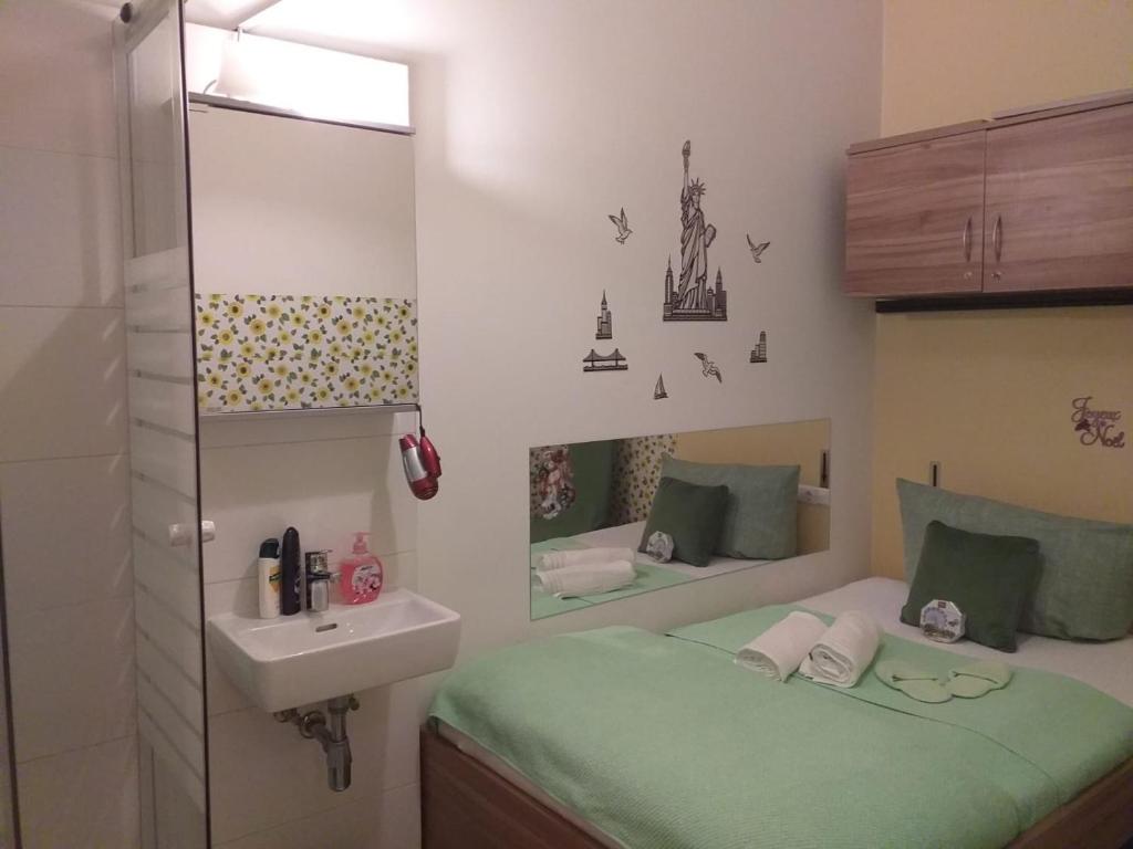 mała łazienka z łóżkiem i umywalką w obiekcie Elisabeth Hostel w Wiedniu