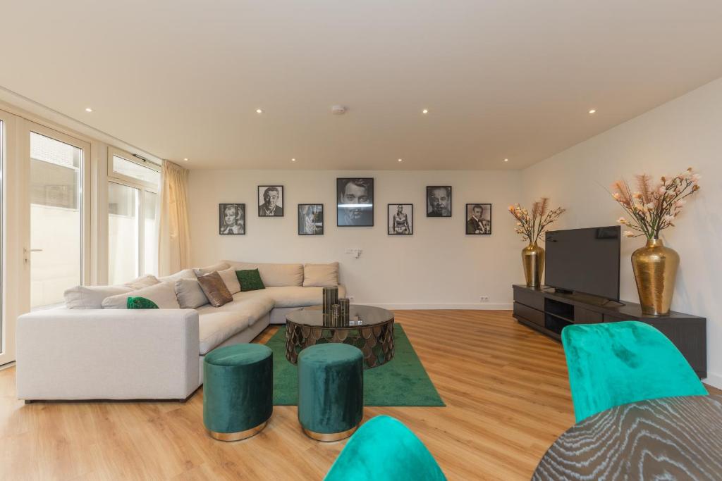 uma sala de estar com um sofá e uma mesa em Lage Wurft Beach Apartments em Noordwijk