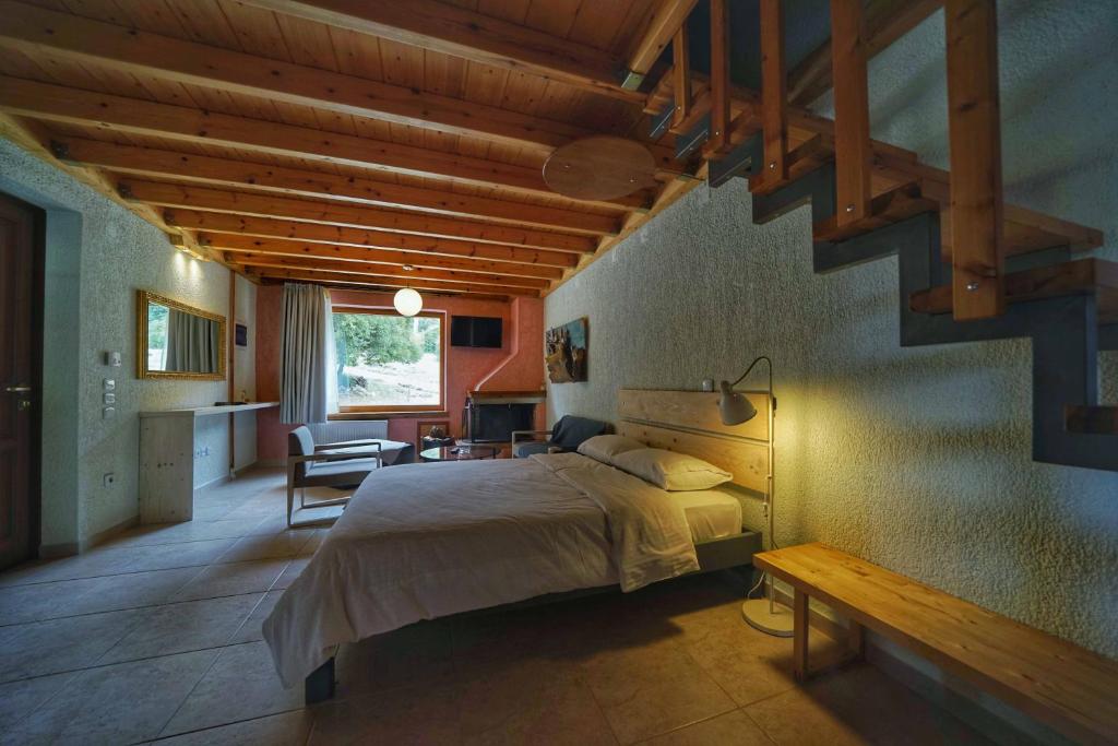 a bedroom with a large bed and a staircase at Livadi Suites in Arachova