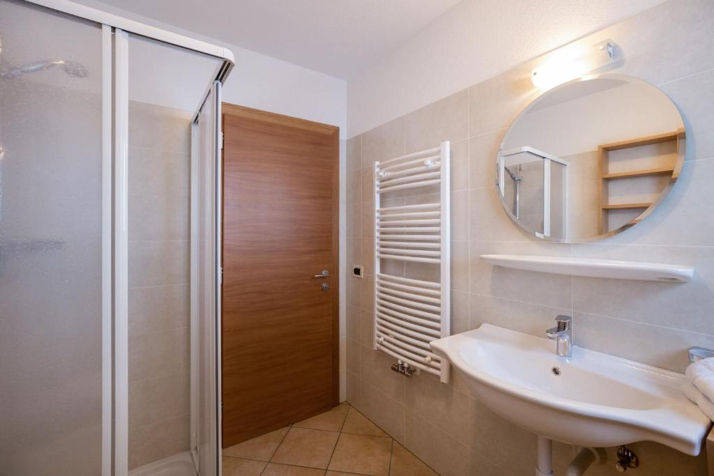 W łazience znajduje się prysznic, umywalka i lustro. w obiekcie Apartment Dolomiten w mieście San Martino in Badia