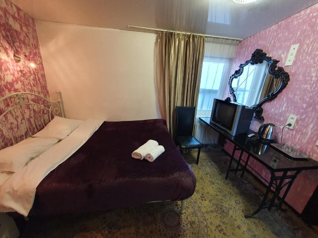 a bedroom with a bed and a mirror and a television at Central Studio Blum in Chişinău