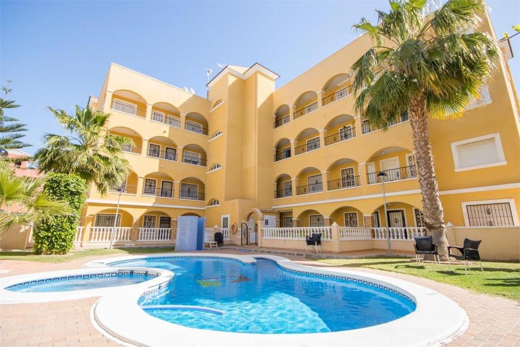 un complejo con piscina frente a un edificio en Apartment Fontana Golf Villamartin, en Orihuela Costa