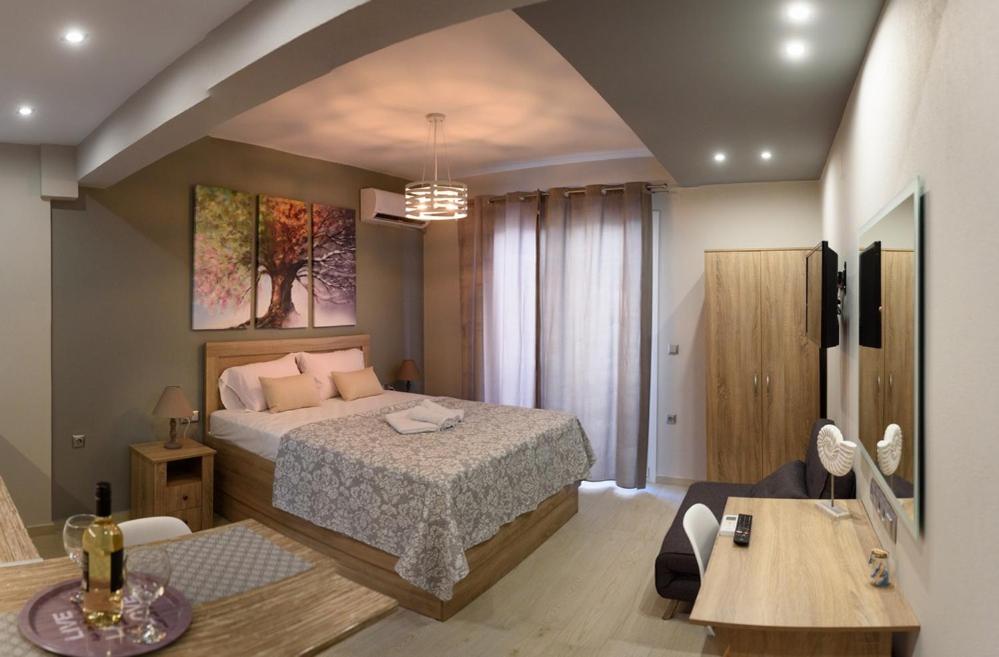 a bedroom with a bed and a table and a desk at Haus Viktoria 1 in Limenas