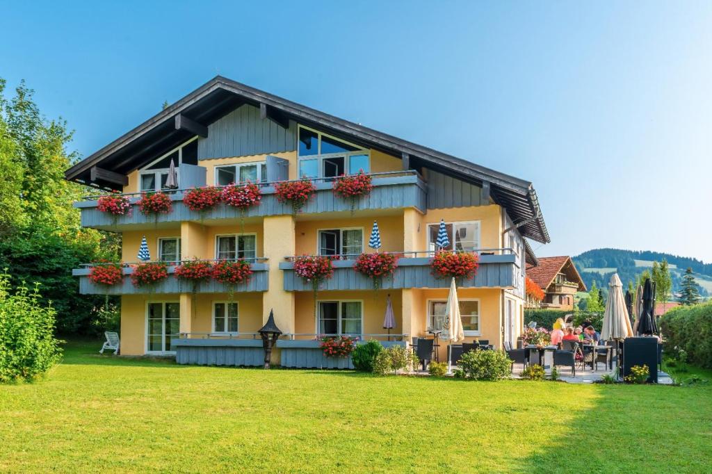 una casa grande con flores en la parte delantera en Hotel Neudeck en Oberstaufen