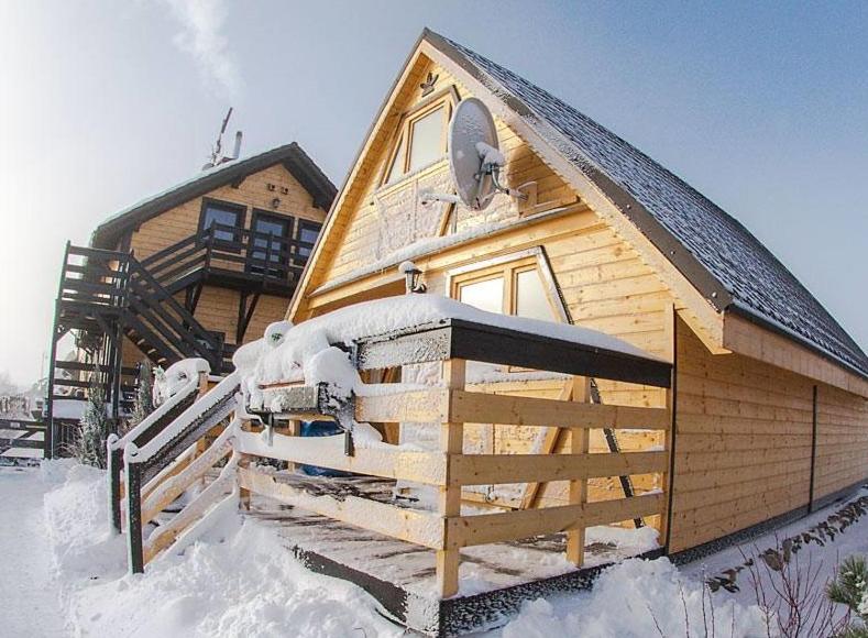 a wooden cabin with snow on the roof at Gościniec Nad Bukówką in Lubawka