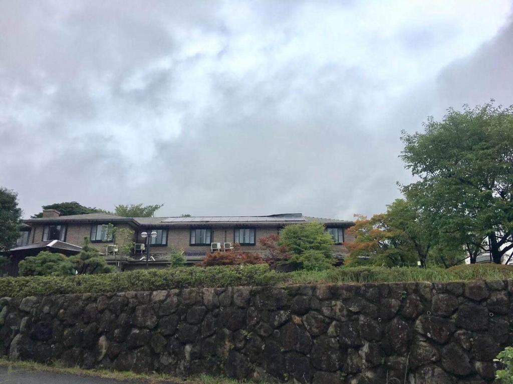 a large house behind a stone wall at Hoshi no Sato in Kirishima