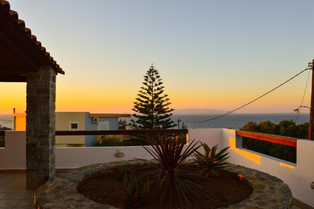 einen Blick auf den Sonnenuntergang vom Balkon eines Hauses in der Unterkunft United blue Resorts - Blue view in Karteros