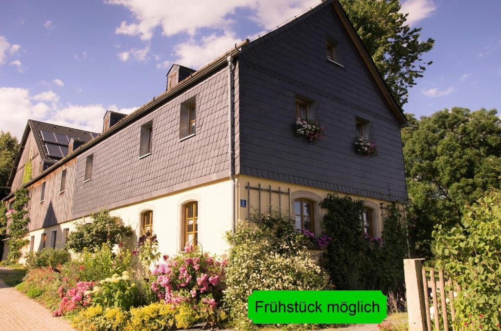 una gran casa blanca con techo negro en Ferienhof Wolfrum, en Berg