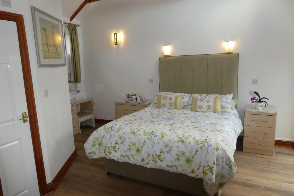 um quarto com uma cama grande e uma cabeceira verde em West View Farm em Louth