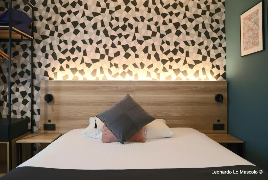 a child is laying on a bed with a pillow at Hôtel de l'Univers Liège in Liège