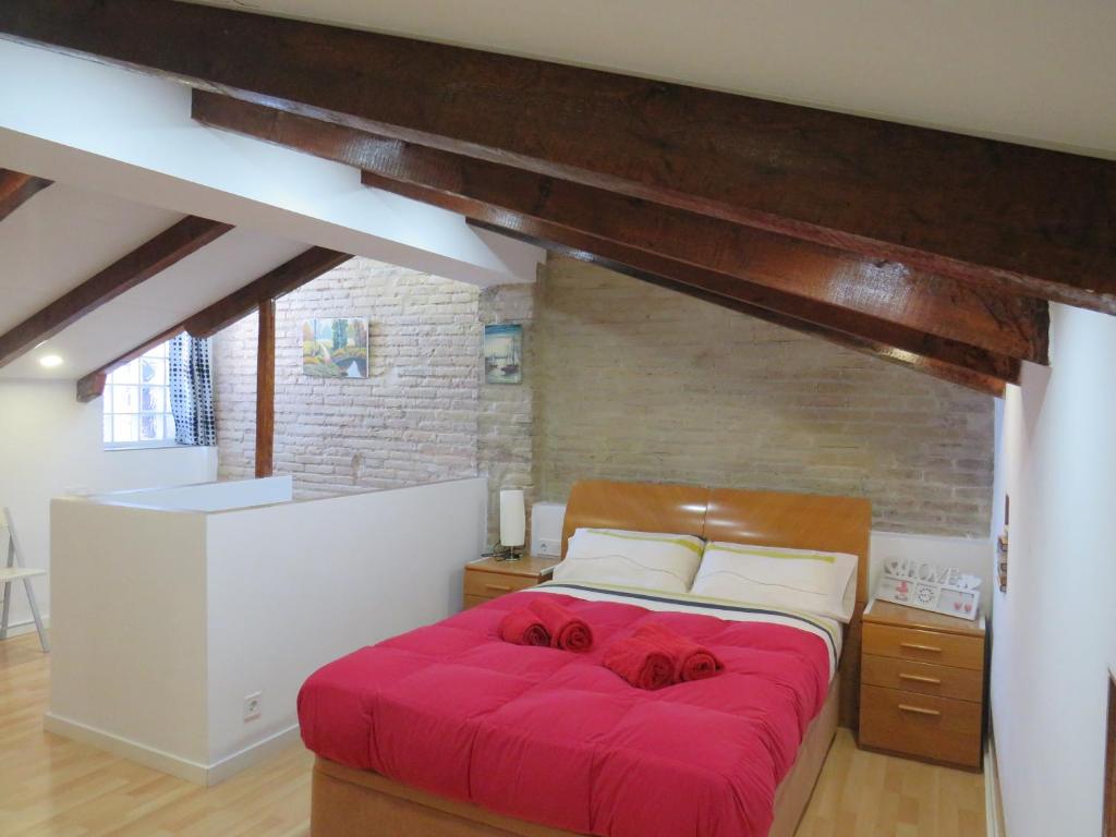 バレンシアにあるCasa La Buhardillaのベッドルーム1室(赤い大型ベッド1台付)
