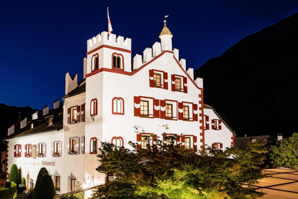 ein großes weißes Gebäude mit einem Turm oben in der Unterkunft Hotel Saltauserhof in Saltaus