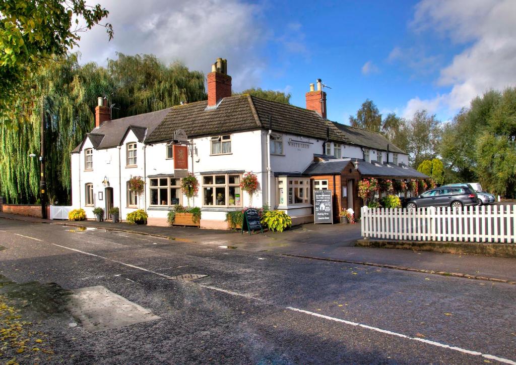 un edificio blanco al lado de una calle en The White Lion Inn, en Oakham