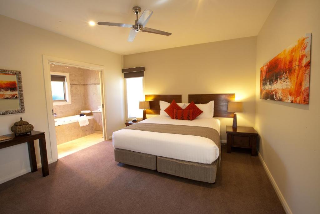 a bedroom with a large bed and a bathroom at Wild Cattle Creek Estate in Wandin Yallock