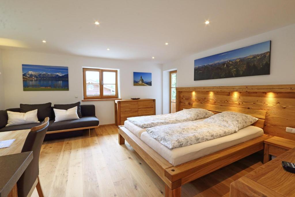 a bedroom with a bed and a couch at Ferienwohnung Haus Hörth in Kreuth