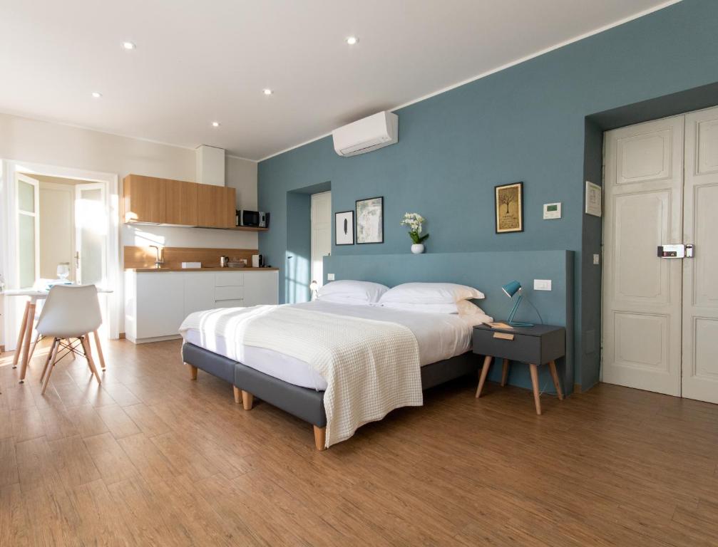 een slaapkamer met een groot bed en een blauwe muur bij Aqualago casa vacanze apartment D in Verbania