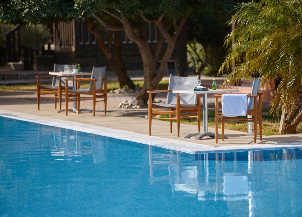 a table and chairs next to a swimming pool at Vasia Resort & Spa in Sisi