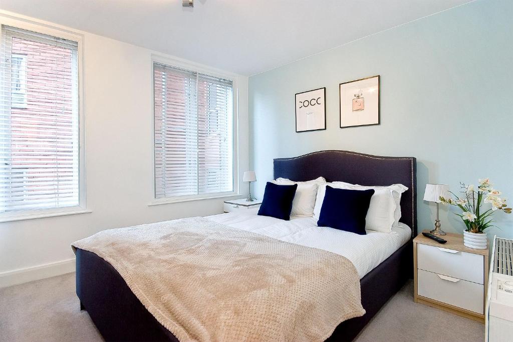 a bedroom with a large bed with blue pillows at Mulberry Flat 4 - Two bedroom 2nd floor by City Living London in London