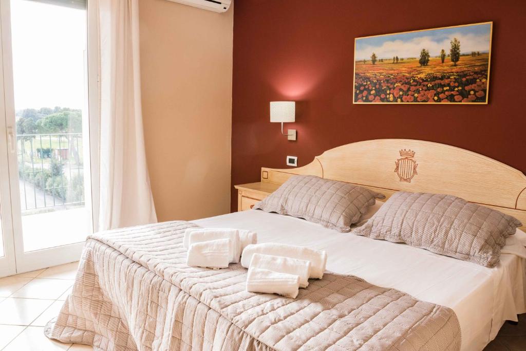 a bedroom with a large bed and a large window at Residenze Santa Costanza in San Vincenzo