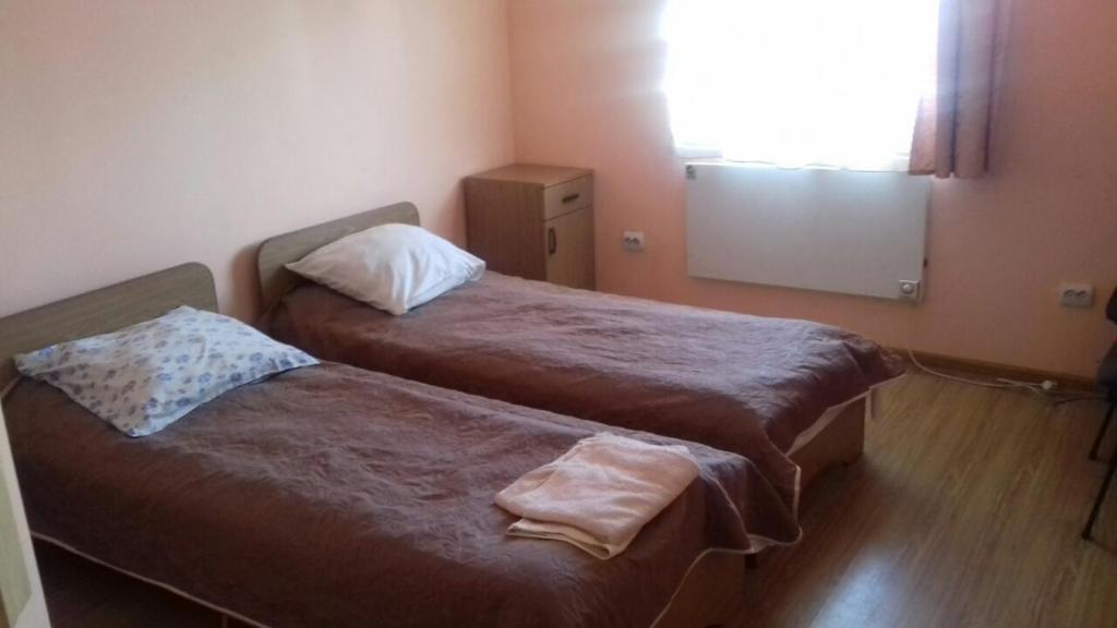 two beds in a small room with a window at Готель АС Ясіня in Yasinya