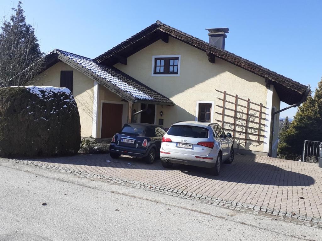 two cars parked in front of a house at Top Apartment in Henndorf am Wallersee