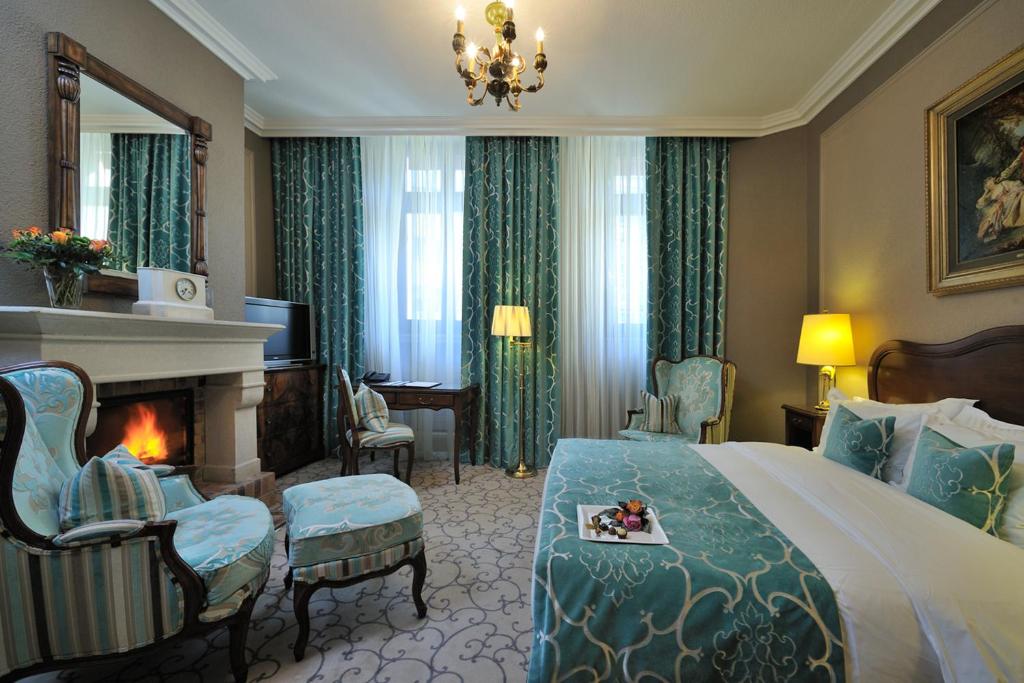 a hotel room with a bed and a fireplace at Hôtel de la Cigogne in Geneva
