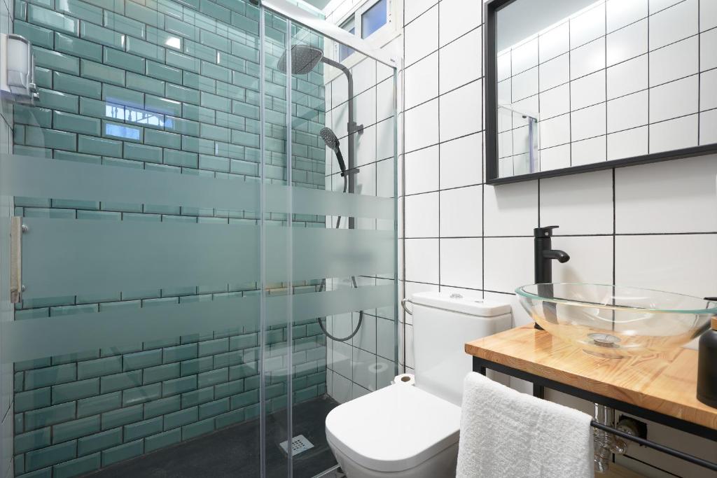 W łazience znajduje się toaleta i przeszklony prysznic. w obiekcie Loft en Triana w Sewilli