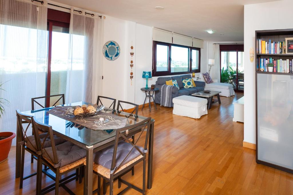 a dining room and living room with a table and chairs at Casa ANA Corralejo in Corralejo