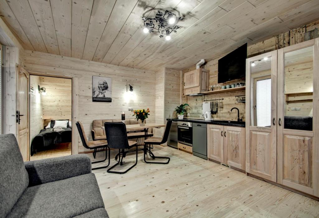 a kitchen and dining room with a table and chairs at Apartamenty Światłomir in Zakopane