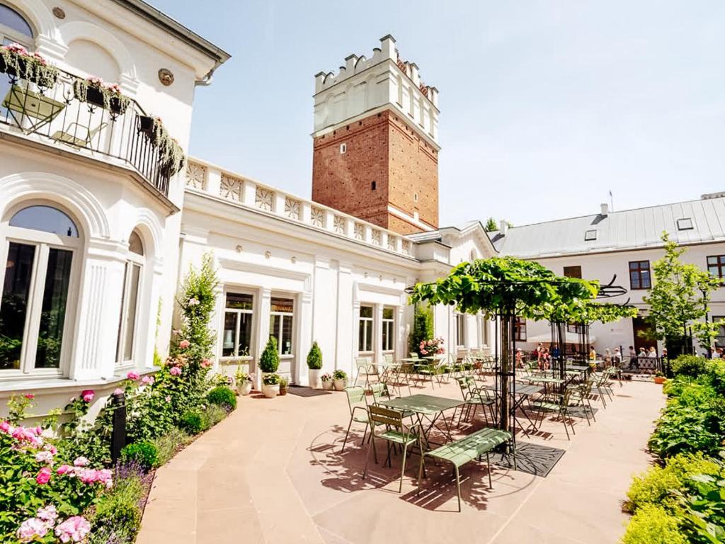 a patio with tables and chairs and a building at Pokoje Gościnne WIDNOKRĄG in Sandomierz