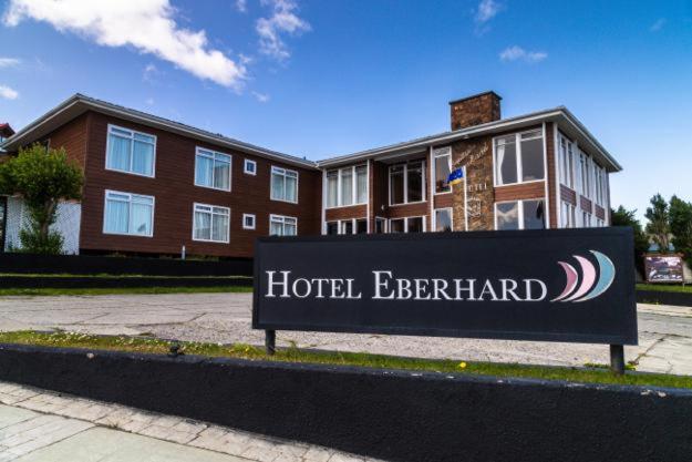una señal de entrada al hotel frente a un edificio en Hotel Capitán Eberhard, en Puerto Natales