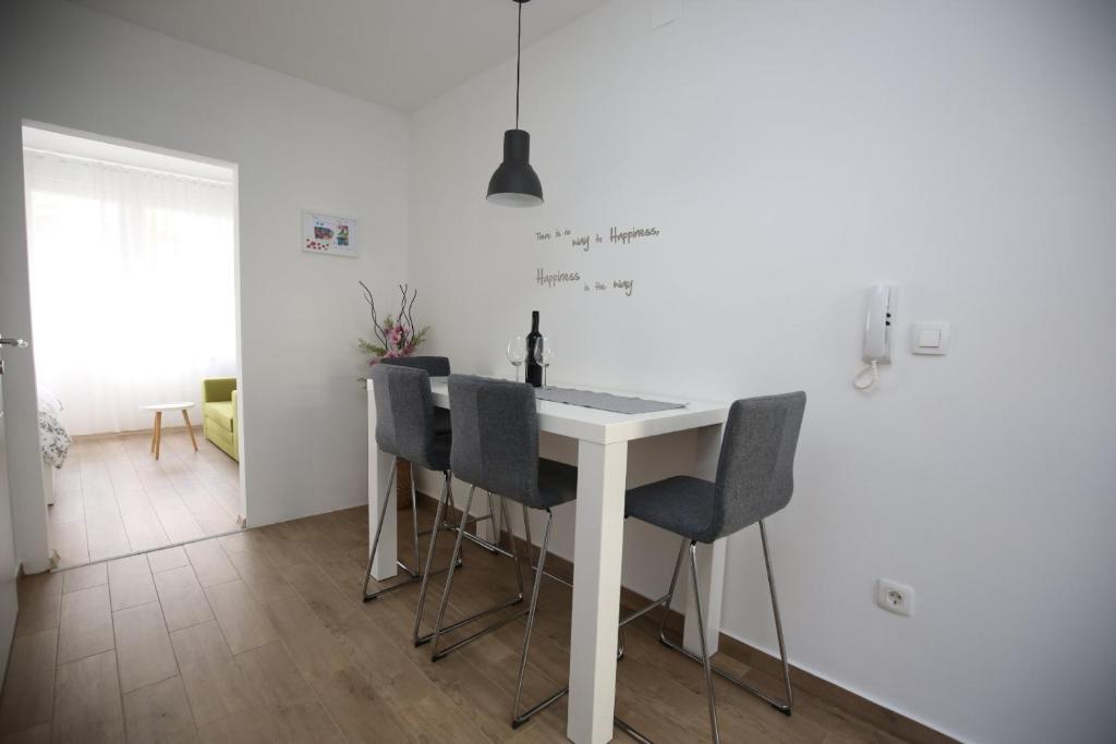 biała kuchnia ze stołem i krzesłami w obiekcie Studio apartment Koko w mieście Rijeka