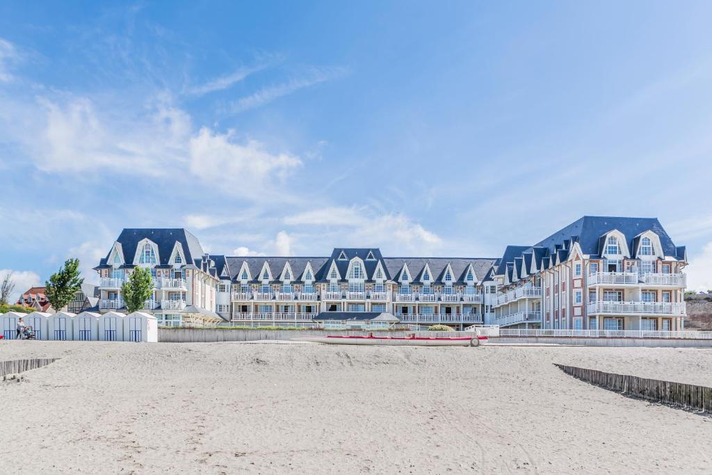 a large building on the beach in front of a building at Pierre & Vacances Premium Résidence de la Plage in Le Crotoy