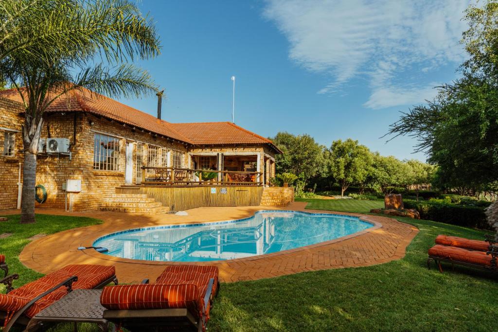 a swimming pool in the yard of a house at Boubou Bed and Breakfast in Rustenburg