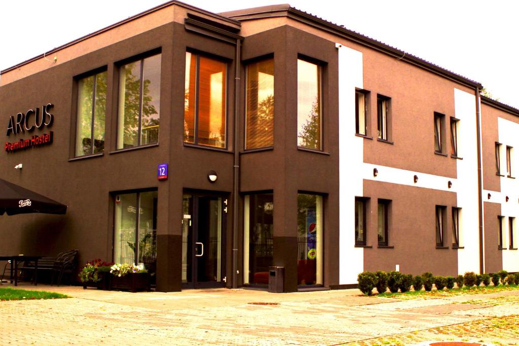 ワルシャワにあるArcus Premium Hostelの側面にガラス戸がある建物