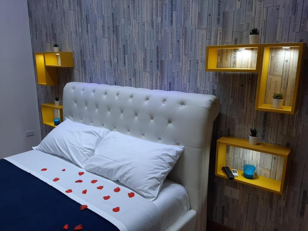 ein Bett mit einem weißen Kopfteil mit Polka-Punkten darauf in der Unterkunft Red House in Neapel