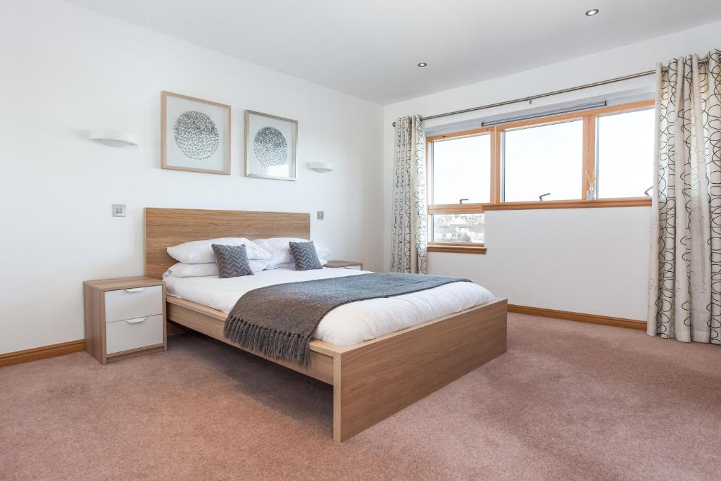 a bedroom with a bed and a large window at Executive 3 Bed Apartment Aberdeen in Aberdeen