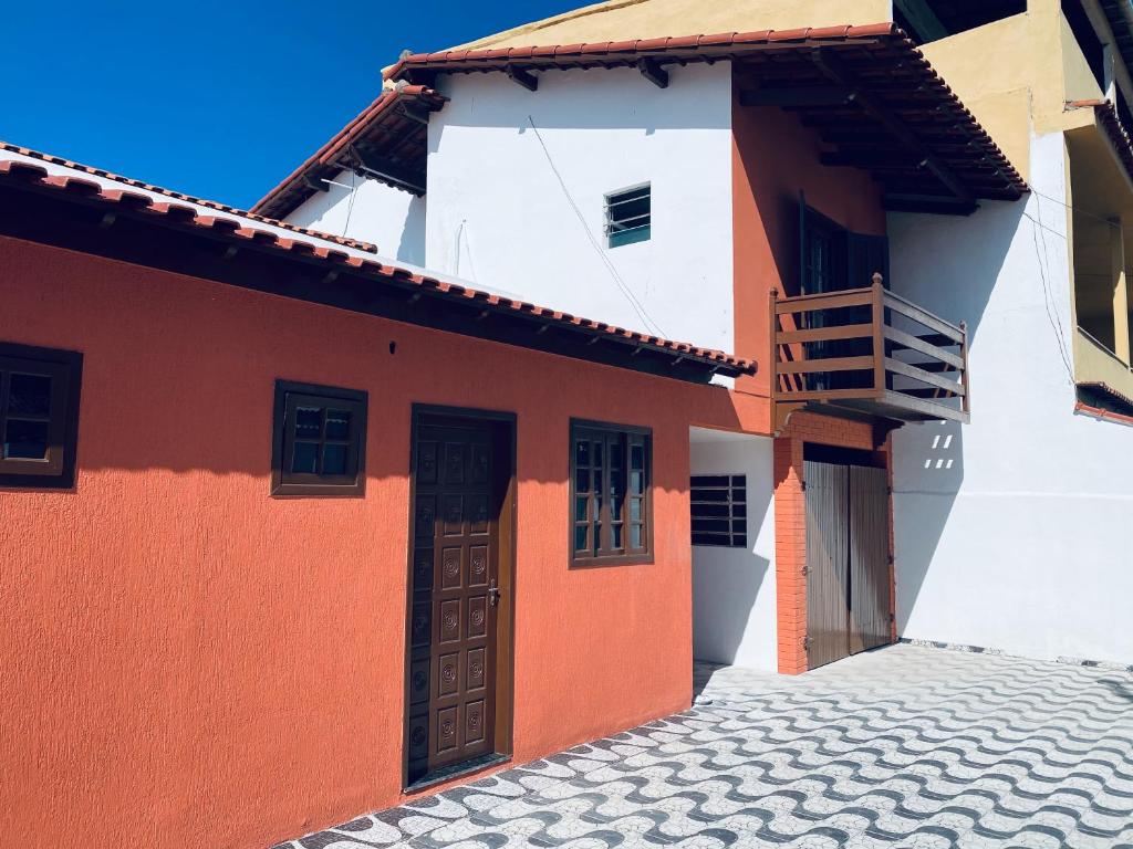 un bâtiment orange et blanc avec une porte dans l'établissement Meus Guris, à Arraial do Cabo