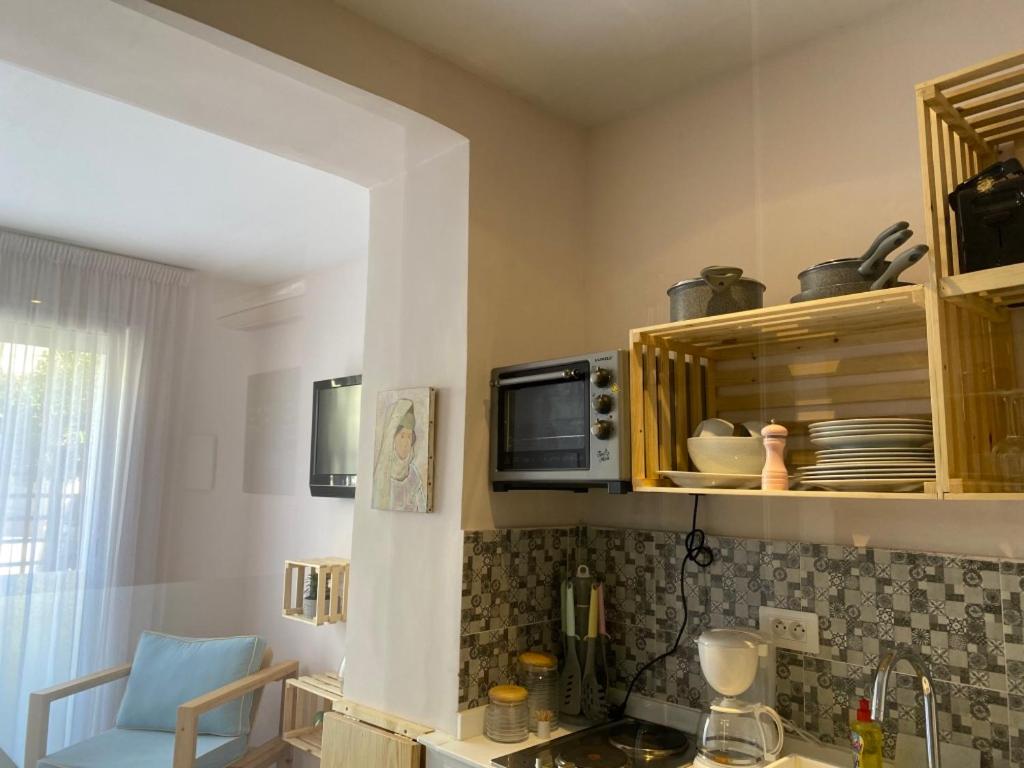 a kitchen with a sink and a microwave at Jardin de bougainvillier in Sfax