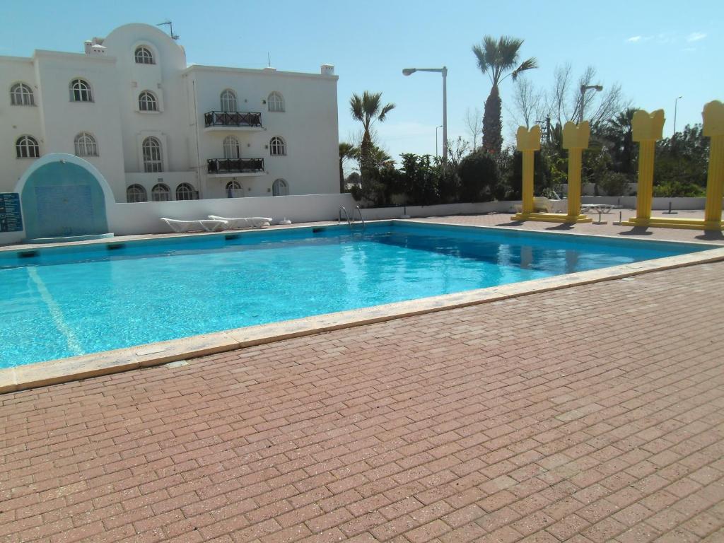 una grande piscina di fronte a un edificio di Tavira Garden a Tavira