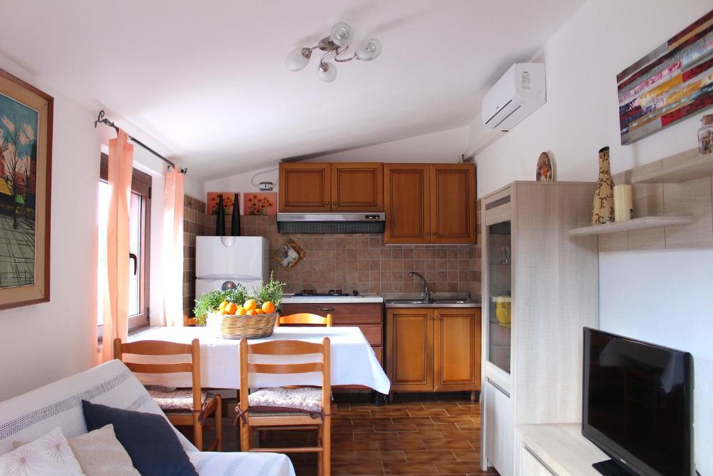 a small kitchen with a table and a dining room at Appartamenti La Conchiglia in Chia