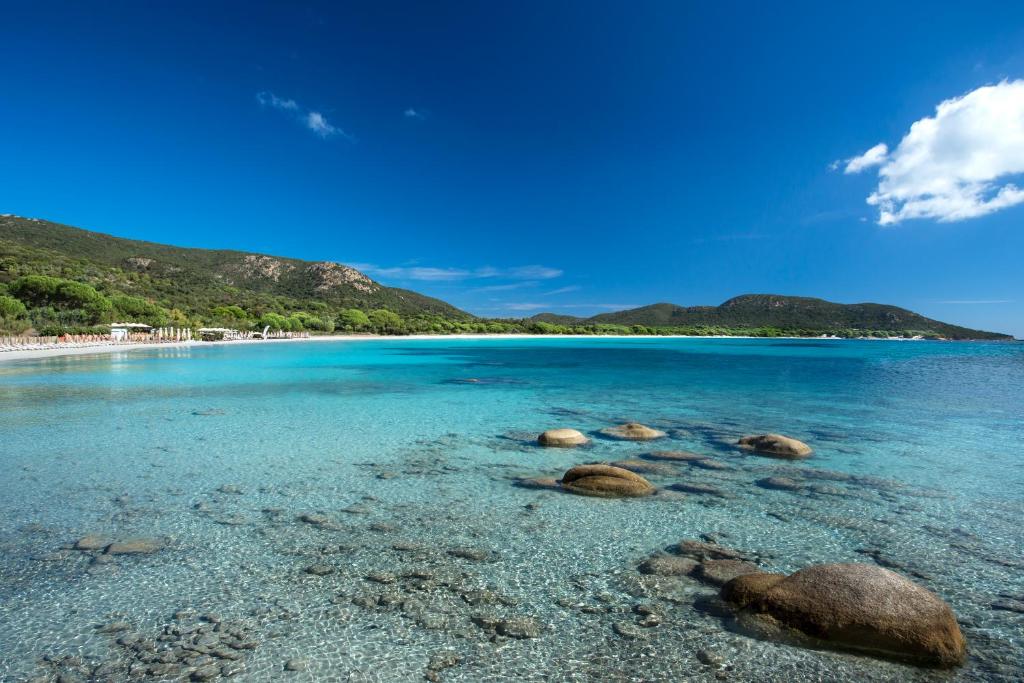 a group of rocks in the water on a beach at Villa Les Lieges de Palombaggia in Porto-Vecchio
