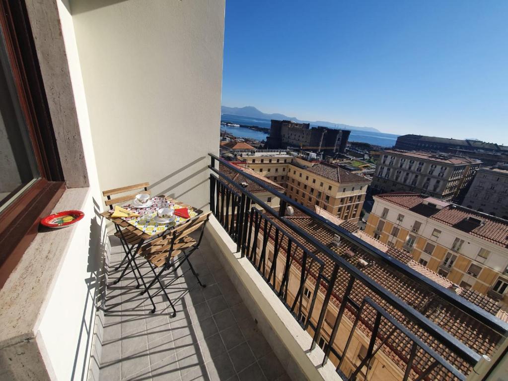 einen Balkon mit einem Tisch und Stadtblick in der Unterkunft NEAPOLITAN SKYSCRAPER APARTMENT in Neapel