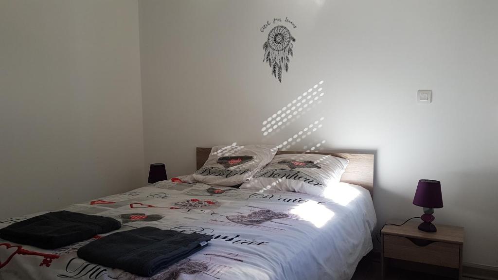 1 dormitorio con 1 cama con sábanas y almohadas blancas en Appartement au pied des 3 Vallées, en Moutiers