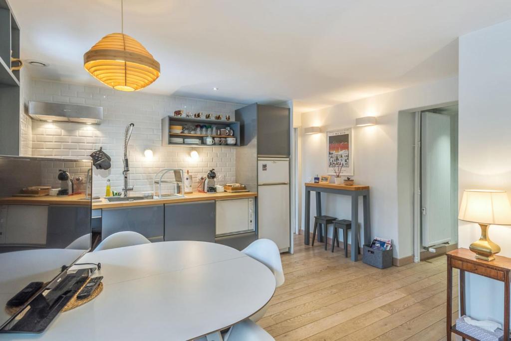 uma cozinha com mesa e cadeiras num quarto em Appartement Odyssée - Welkeys em Megève