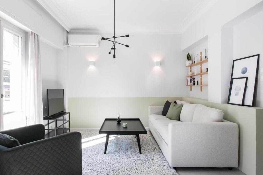 a living room with a couch and a table at Deluxe & Stylish 2BD Apartment in Pangrati by UPSTREET in Athens